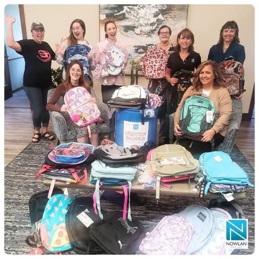 Nowlan team members presenting all the donated backpacks to Emily at ECHO